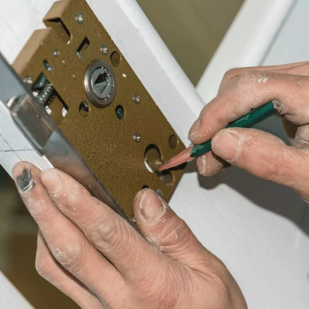 Serrurier Lyon 17 Serrurier à Feyzin marquant l'emplacement pour installer une serrure encastrée sur une porte en bois