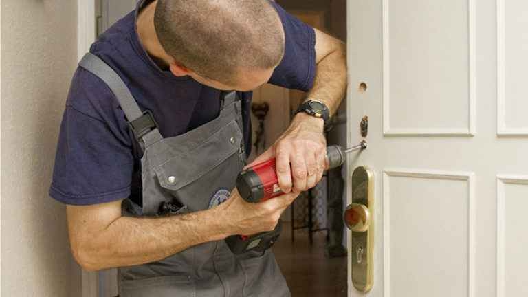 Photo : serrurier utilisant une perceuse sur une serrure de porte à Genas.