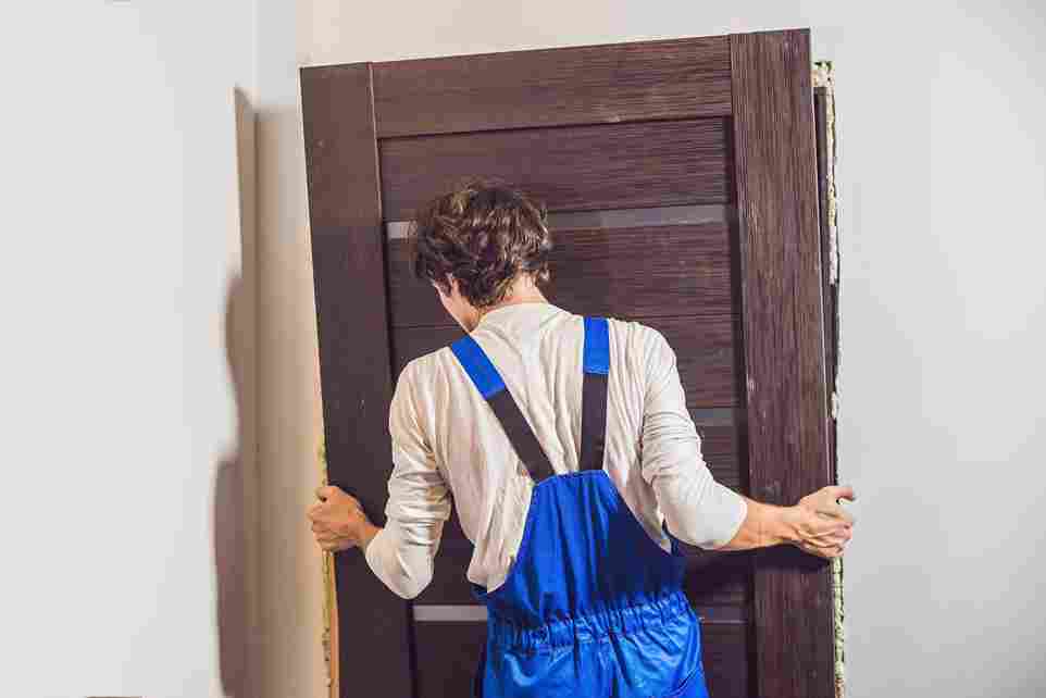 Artisan serrurier Givors en pleine pose d’une porte d’entrée moderne, intervention rapide pour remplacement ou sécurisation d’accès.
