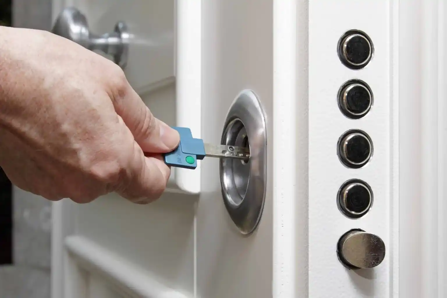 Serrurier Lyon 8 procédant à l’ouverture ou à l’installation d’une porte blindée, main tenant une clé de sécurité devant le blindage